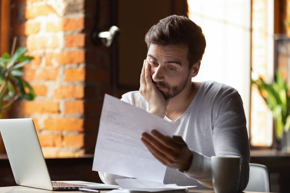 Stressed man reading reservation of rights letter