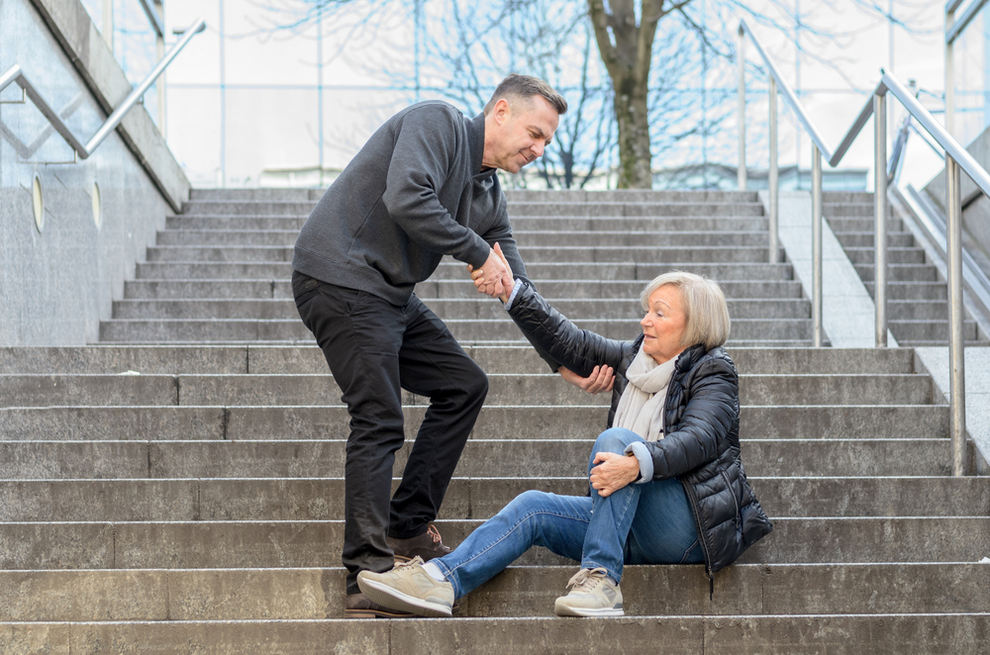 Man helping senior woman get up