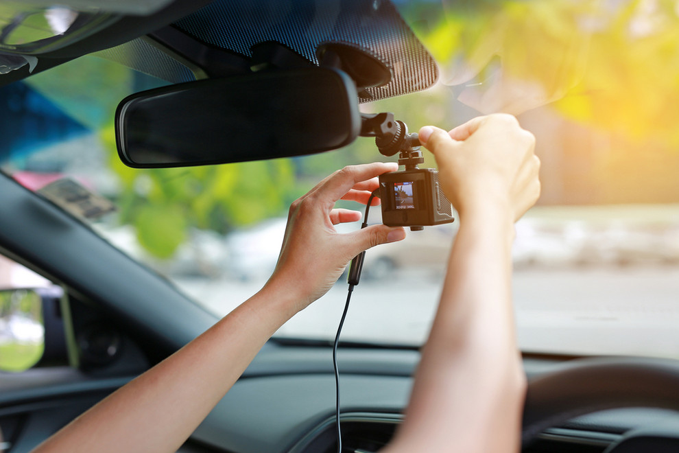 Woman installing dash cam in car