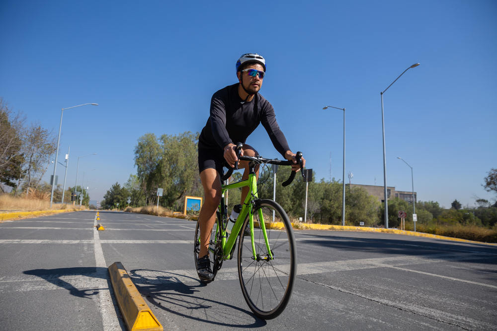 Bicyclist riding bike in the city waring a helmet