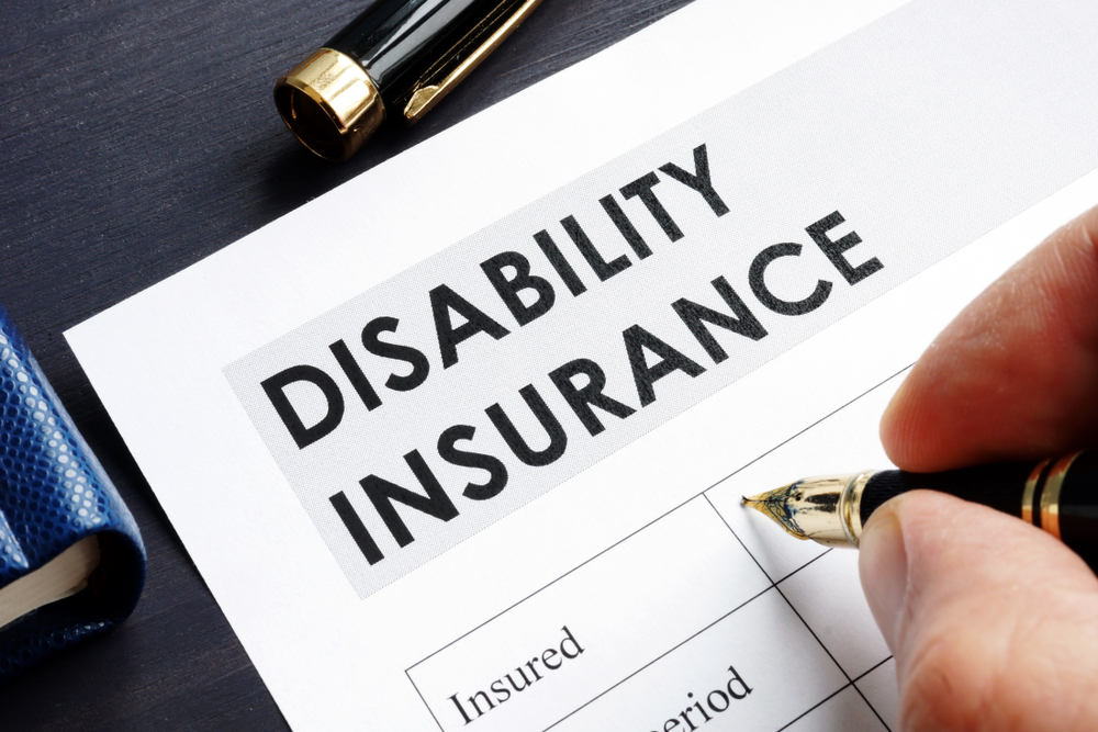 Man is filling in Disability insurance form (Is Long Term Disability Taxable)