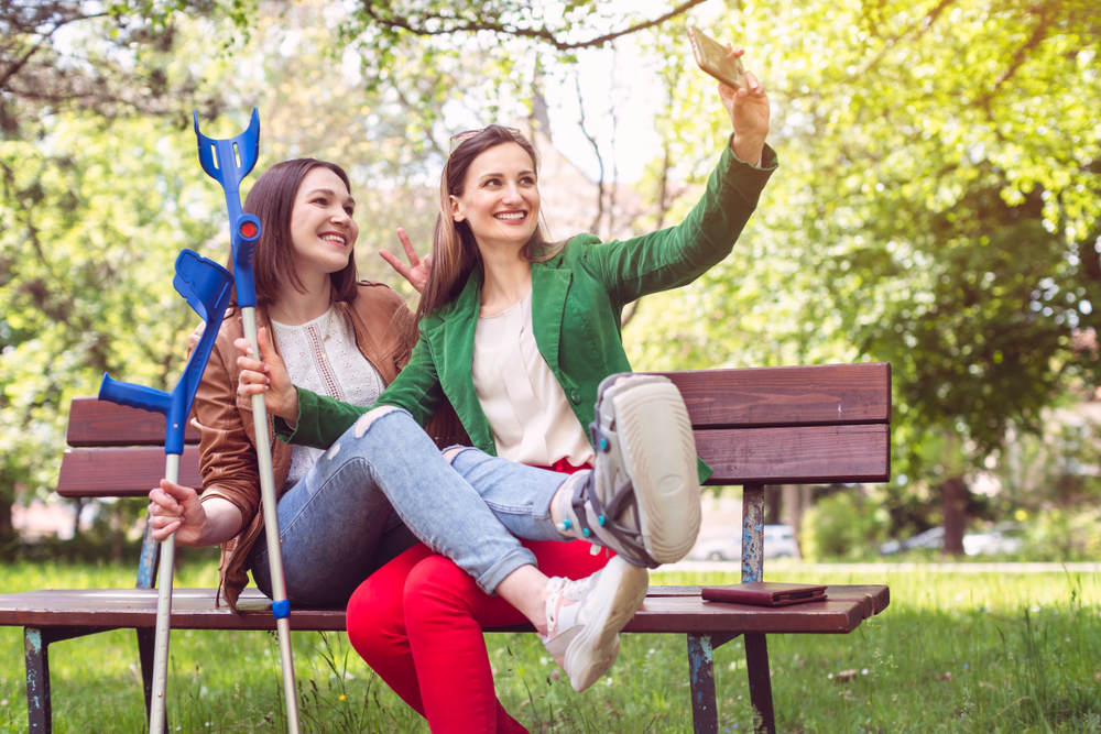 Injured girl taking pictures with friend