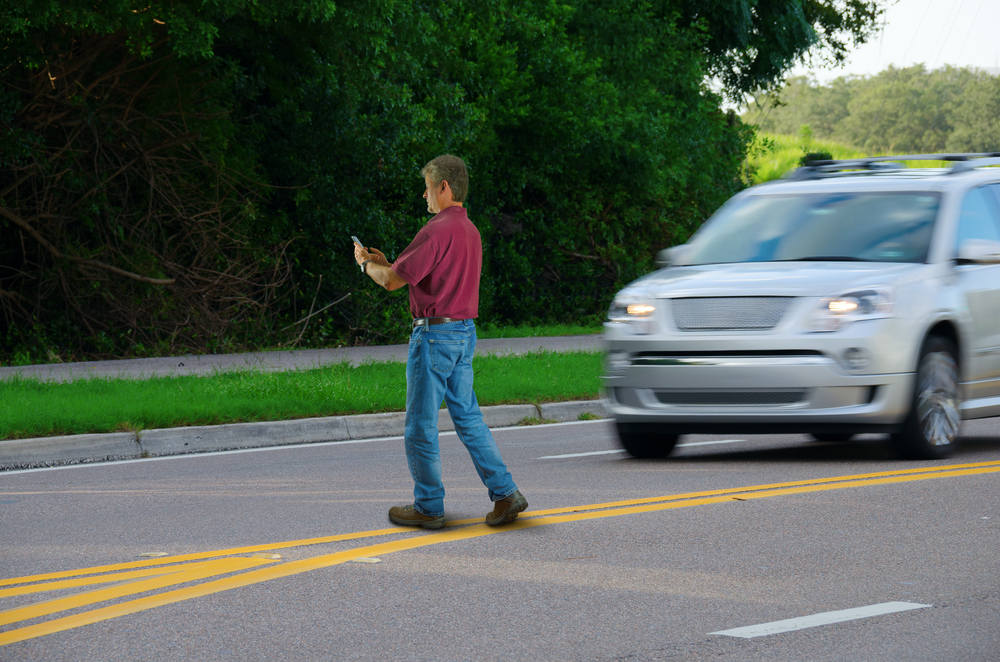 Man crossing the street unsafely (Is Jaywalking Illegal in California)